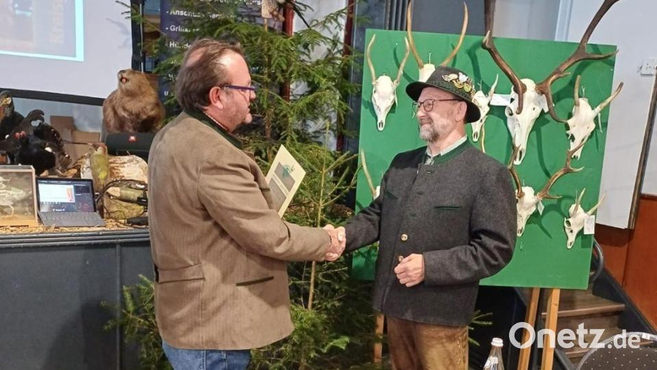 Kreisgruppenvorsitzender Christian Ertl (links) überrascht Hornmeister Eduard Forster aus Eslarn (rechts) mit der Bläsertreuenadel in Gold. Immerhin ist Forster seit 38 Jahren ununterbrochen auch Hornmeister der musikalischen Gruppe. Eine Auszeichnung mit Seltenheitswert in der Region. Bild: dob