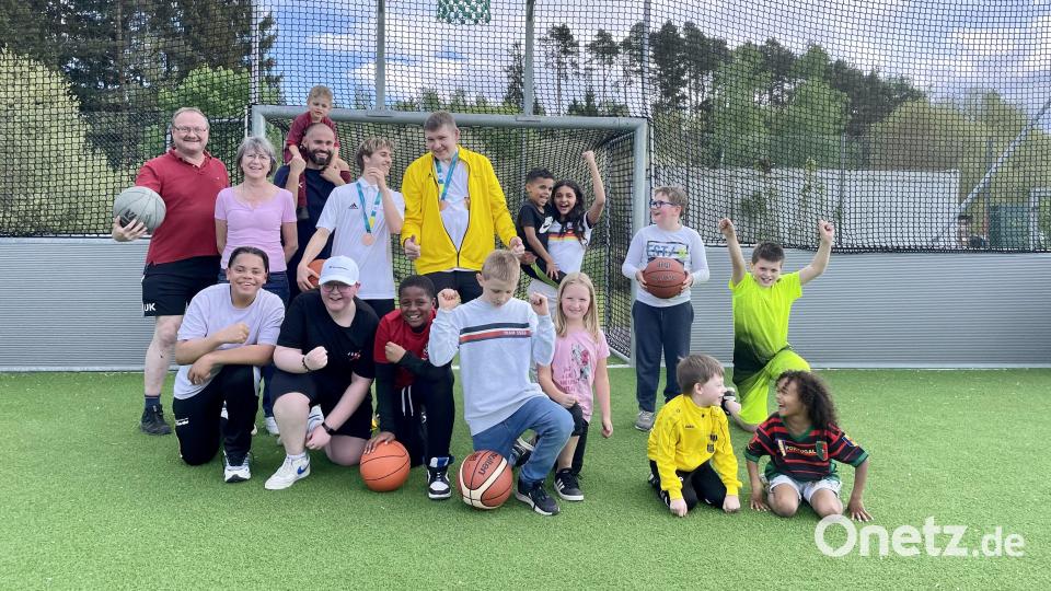 Sandro Lobenhofer und Josef Dobmeier (Bildmitte) umringt von Kindern nach einem gemeinsamen Basketballspiel. Bild: Krones