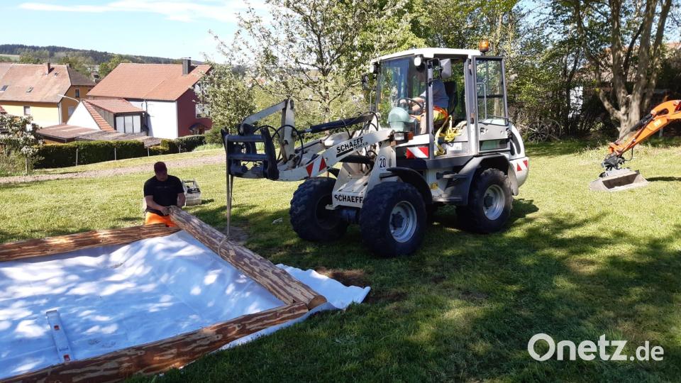 Der Bauhof legt den Sandkasten mit gespendeten Rundhölzern an. Bild: gz