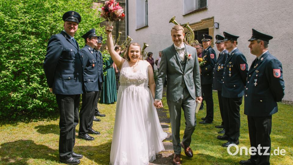 Rebecca und Andreas Ermer schreiten bei strahlendem Sonnenschein durch das Ehrenspalier ins Eheglück Bild: bk