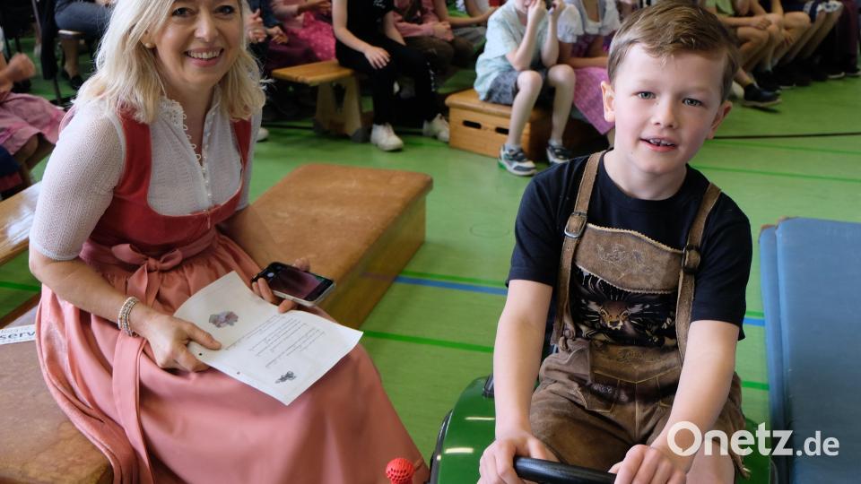 Tom Kastner holt passend zum Lied „Becci, i hol‘ Di mit meim Traktor ab“, aus der Garage, worüber sich auch Konrektorin Gunda Hartinger freut. Bild: le