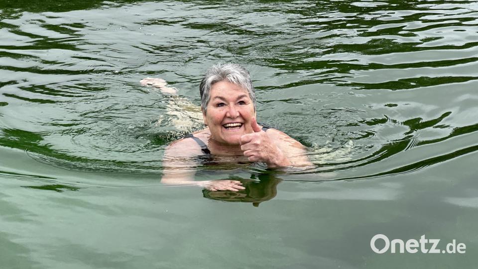 Ingrid Müller war bei 12 Grad Luft- und 18 Grad Wassertemperatur die erste Schwimmerin im Becken. Dafür gab es Blumen vom Bürgermeister. Bild: e