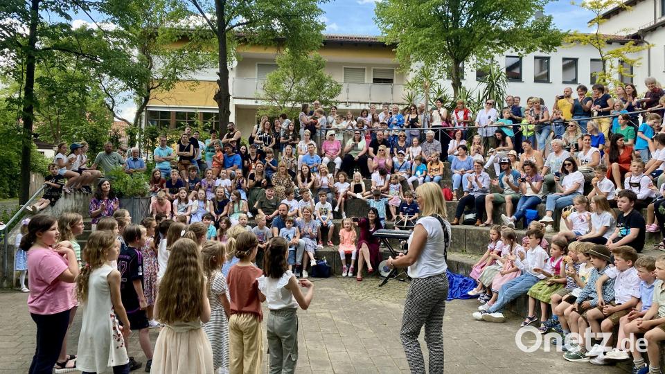 Viele Gäste feiern die &quot;musikbegeisterte Grundschule&quot; Freudenberg und bewundern die Darbietungen draußen im Pausenhof. Bild: gri