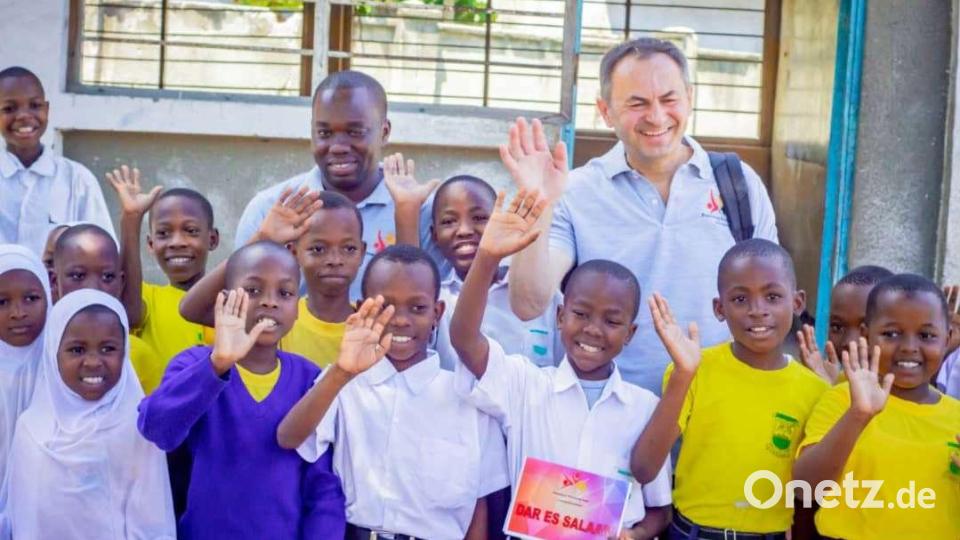 Pfarrer Martin Rupprecht mit Filialleiter Alphonce Leonard und einigen frohgelaunten Schützlingen in Tansania, die sich über die Arbeit der Stiftung freuen. Bild: gz