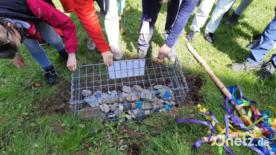 In einem Gabionenkorb werden die von den Lobkowitz-Realschülern mitgebrachten Steine einstweilen aufbewahrt. Sie sollen das Fundament eines geplanten Freiluftaltars vor der Wallfahrtskirche St. Quirin bilden. Bild: Marion Beugler/exb