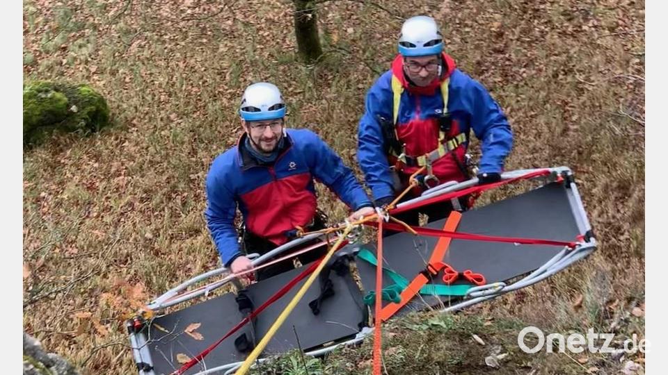 Zwei Bergretter werden mit Gebirgstrage zum Wandfuß abgelassen. Bild: Bergwacht Sulzbach-Rosenberg/exb
