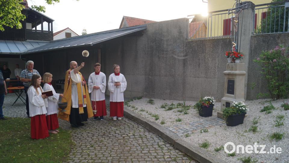 Pfarrer Hans Spitzhirn segnet das Dorfkreuz, das jetzt beim Kriegerdenkmal steht. Bild: slh