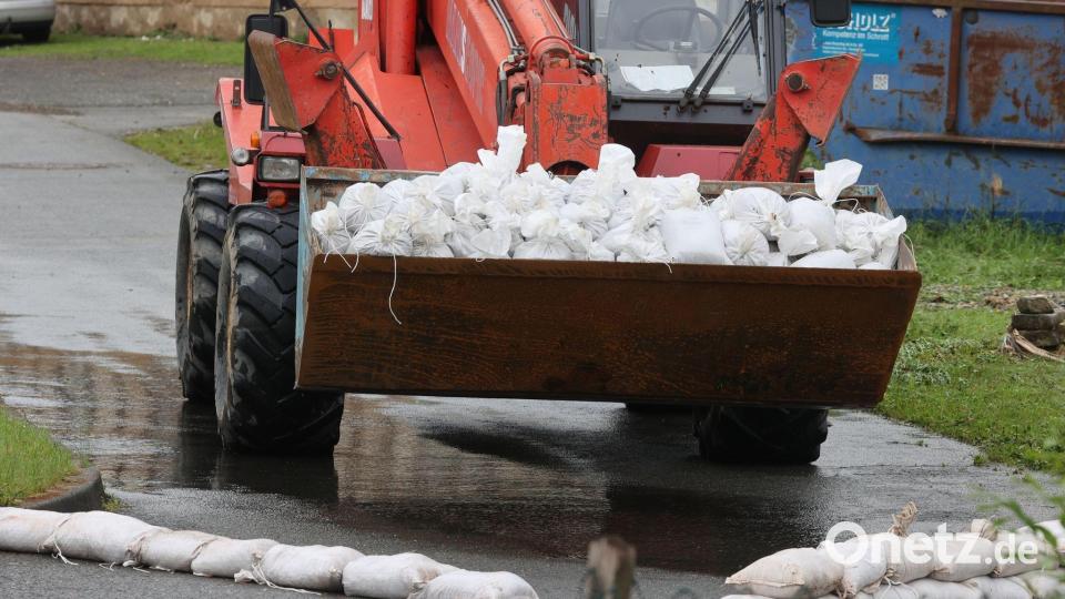 Ein Radlader transportiert in Hilbersdorf in Ostthüringen Sandsäcke. Bild: Bodo Schackow/dpa