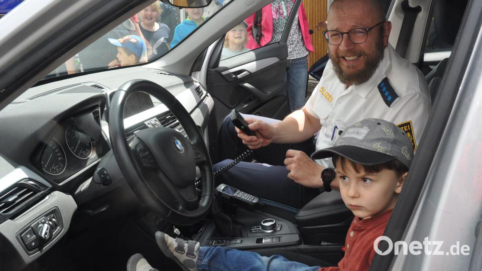 Wenn ich groß bin, möchte ich auch zur Polizei. Verkehrserzieher Wolfgang Piehler erklärt dem kleinen Steppke das Blaulicht. Bild: dob