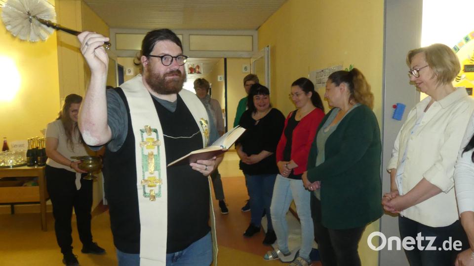 Mit dem Kindergartenteam begann Pfarrer Johannes Bosco Ernstberger die Segnung des Übergangskindergartens. Bild: rn