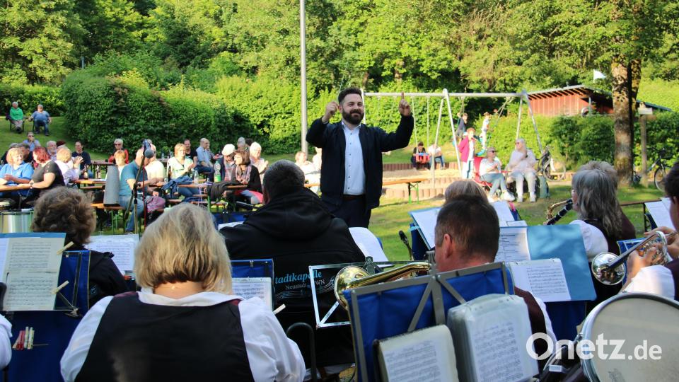 Bürgermeister Sebastian Giering dirigiert die Stadtkapelle beim Bayerischen Defiliermarsch bei der ersten Sommer-Serenade, die die Neustädter Musikschule mit verschiedenen Ensembles gestaltete. Bild: prh