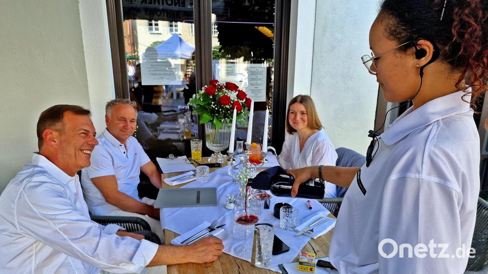 Ein Paar feiert ein Kennenlernjubiläum beim &quot;Diner en blanc&quot; mit roten Rosen. Bild: R. Kreuzer