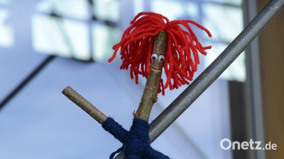 Ein kleiner Ast wird mit Wolle und bunten Klebestreifen unbestritten, wenn auch mit viel Phantasie ein menschliches Aussehen gegeben. Bild: bey
