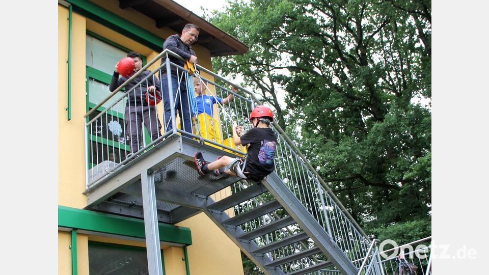 Verschiedene Stationen werden den Kindern zur Unterhaltung angeboten. Das Abseilen von der Fluchttreppe erfordert schon etwas Mut von den Kindern. Doch Jürgen Dietl hat alle stets im Griff. Bild: Josef Böhm