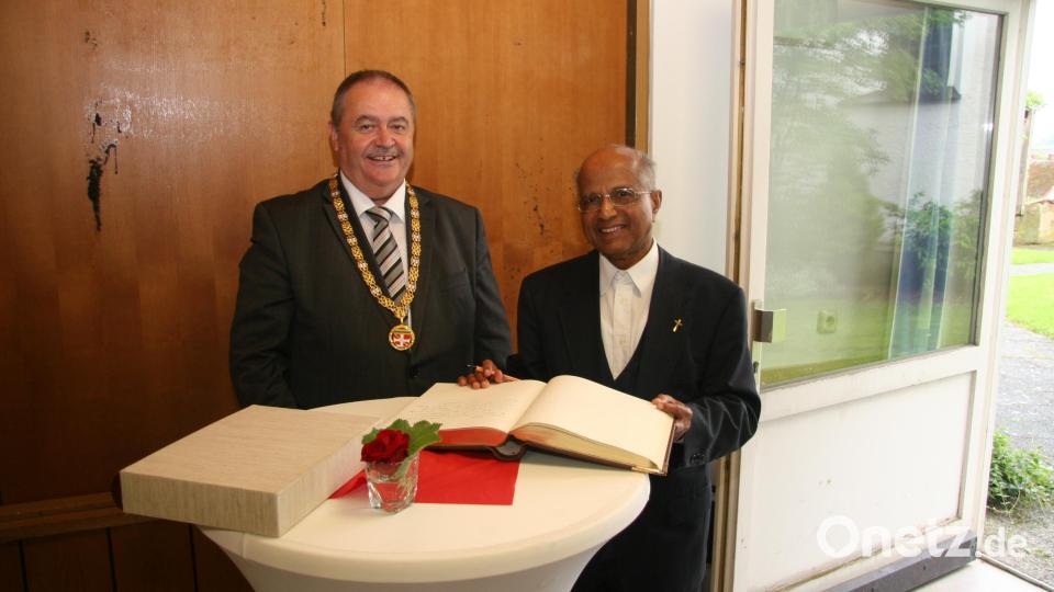 Der Eintrag von Pfarrer Joseph (rechts) ins Goldene Buch der Gemeinde gehört bei der Jubiläumsfeier dazu. Gleich hinter dem Bayerischen Innenminister Joachim Herrmann, wie Bürgermeister Peter Dotzler betonte. Bild: swo