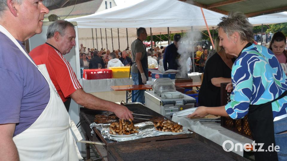 Robert Mittelmeier (Zweiter von links) und Pfarrgemeinderatssprecher Manfred Bauer (links) kümmern sich um das Grillgut. Petra Hager (rechts) füllt die Teller zum Mittagessen. Bild: dob