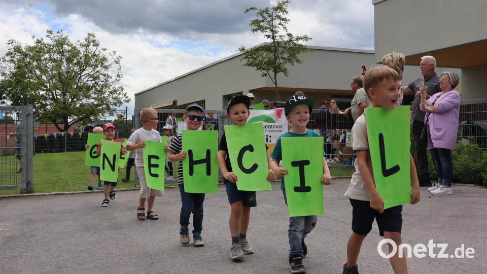 Beim Festzug tragen alle Kinderoasenkinder Buchstaben durch die Menge: Glückwünsche an den Kindergarten St. Emmeram. Bild: wrm