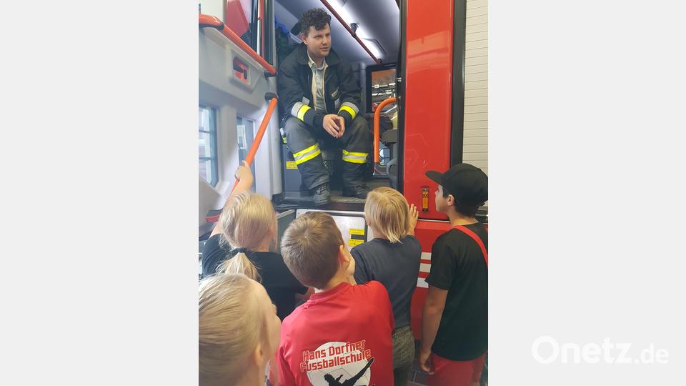 Jugendwart Felix Kubitschek erklärt den Kindern das Feuerwehrauto. Bild: Grundschule Waldsassen/exb