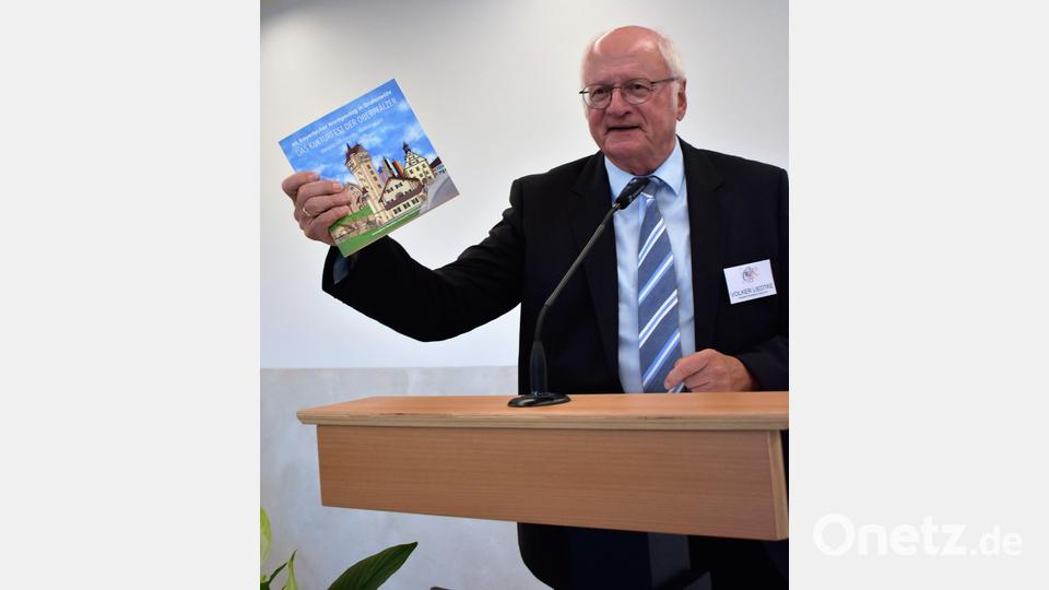 Volker Liedtke, der Präsident des Oberpfälzer Kulturbunds und Altlandrat des Landkreises Schwandorf, legt den Festgästen die 270-seitige Festschrift mit 40 Beiträgen ans Herz. Bild: rgr