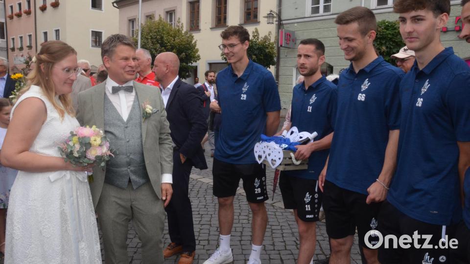 Das Hochzeitspaar Loreen und Benjamin Zeitler plaudert mit Spielern der SpVgg SV Weiden. Bild: Kunz