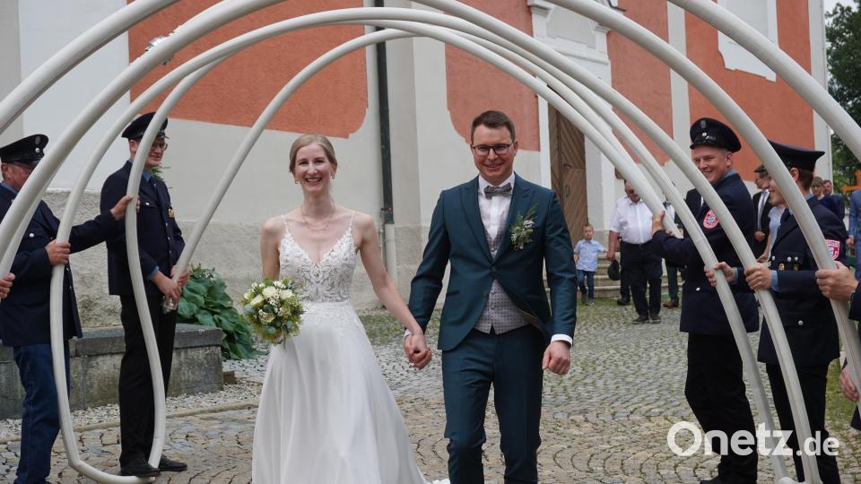 Lisa und Alexander Löw schreiten strahlend durch das Spalier der Freiwilligen Feuerwehr Neualbenreuth. Bild: jeb