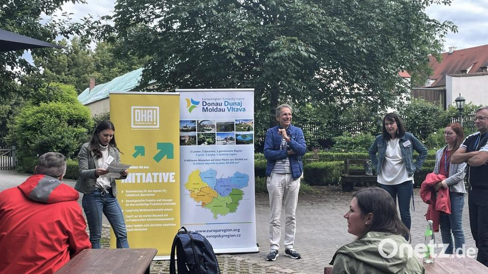 Verena Nirschl von der Europaregion Donau Moldau (vor den Bannern links) und Eduard Wagner von der Initiative OHA! (rechts) hießen die Teilnehmerinnen und Teilnehmer zum Ge(h)spräch auf dem Mariahilfberg willkommen. Bild: Susanne Schwab