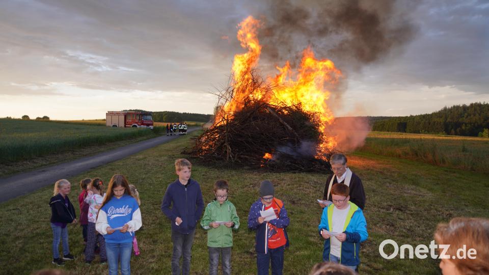 Pfarrer Norbert Götz segnet das Johannisfeuer bei Woppenrieth. Einige Mädchen und Buben lesen Fürbitten. Bild: fvo