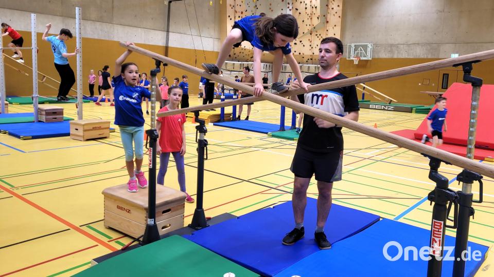 Andreas Dehling, Abteilungsleiter der Lauftreffsparte des SVI, mit Kindern an den Turngeräten in der Turnhalle des Sportcamps Nordbayern. Bild: no