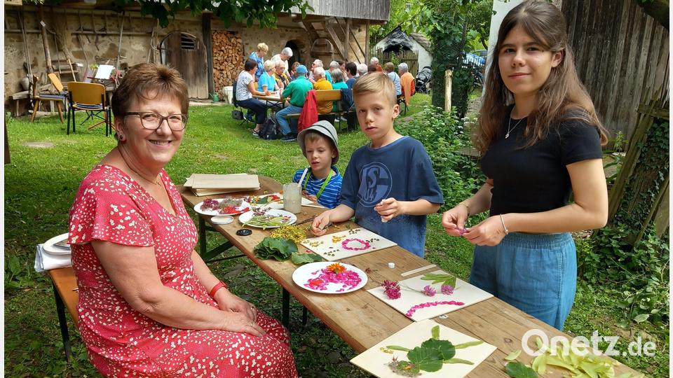 Elfriede Winter leitet die Kinder beim Basteln an. Klara (rechts), Jakob (Zweiter von rechts) und Elias formten Blüten und Blätter zu bunten Bildern. Bild: hka
