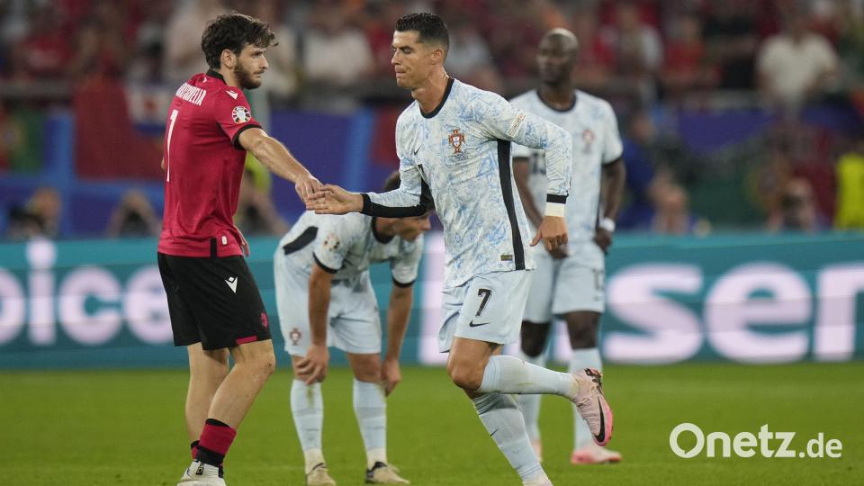 Mini-Schienbeinschoner und Abklatschen mit großem Vorbild: Georgiens Chwischa Kwaratschelia (links) hat gegen Cristiano Ronaldos (rechts) Portugiesen stark aufgespielt. Bild: Alessandra Tarantino/AP