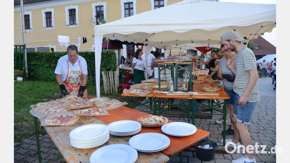 Unterm Zeltdach werden Teigfladen belegt, bevor sie dann mit allen Zutaten in den Pizzaofen eingeschoben werden. Bild: bey