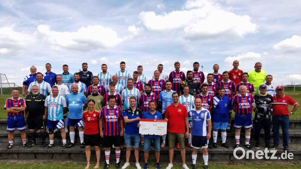Die beiden Fanclubs vom FC Bayern und 1860 München bei der symbolischen Checkübergabe, überreicht von Marco Stöckl (FCB) und Fabian Brenner (1860) an Stefan Singer und Thomas Meckl (TSV Eslarn). Bild: gz