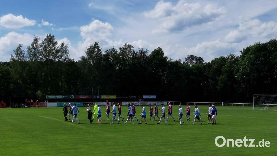 Schiedsrichter Bernhard Grötsch führt die beiden Teams zum Anstoßpunkt. Bild: gz