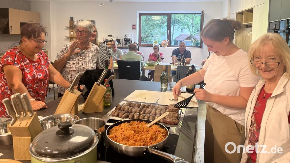 Renate Würstl (rechts) zeigte den Teilnehmern die Zubereitung köstlicher Cevapcici. Bild: Marco Kellner/exb