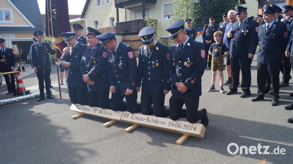 Kniend bitten die Mitglieder der Feuerwehr Weihern die Feuerwehr Losau-Schiltern um die Übernahme der Ehrenpatenschaft. Bild: slh