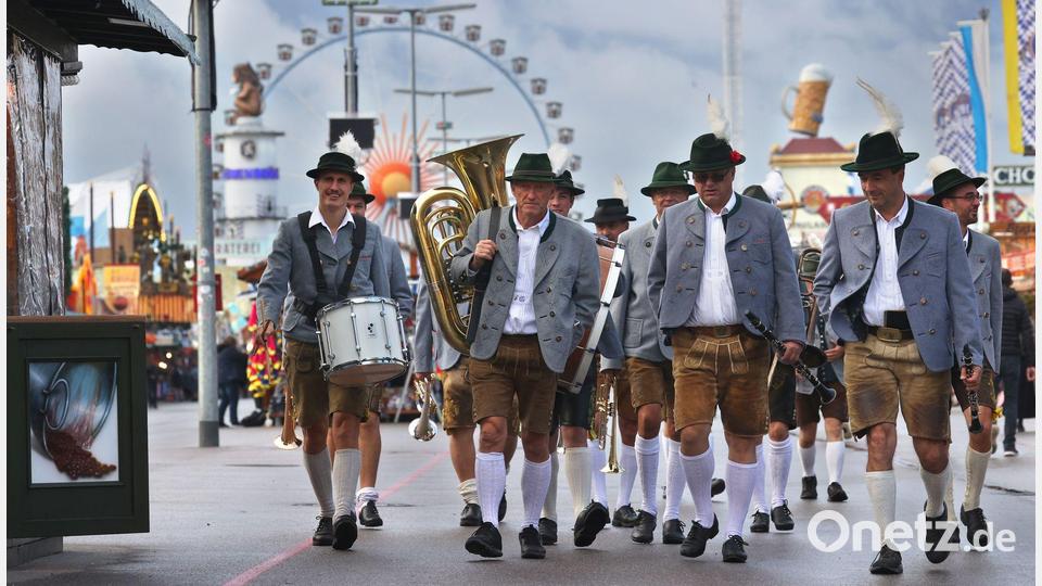 Blasmusiker gehen vor dem Riesenrad über den Festplatz. (Archivbild) Bild: Karl-Josef Hildenbrand/dpa