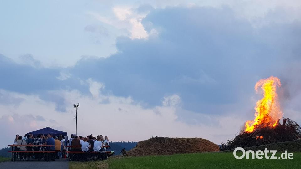 Beim lodernden Johannisfeuer lässt es sich gut sitzen und feiern. Bild: gi