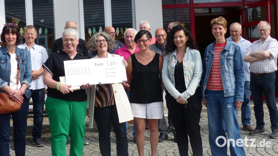 Elternbeiratsvorsitzende Manuela Beck (vorne Vierte von rechts) überreicht an Ideengeberin von „‚Pausenfutter‘ für ‚Lesefutter‘“ Simone Friedl eine Spende in Höhe von 150 Euro für die Bücherei. Bild: sl