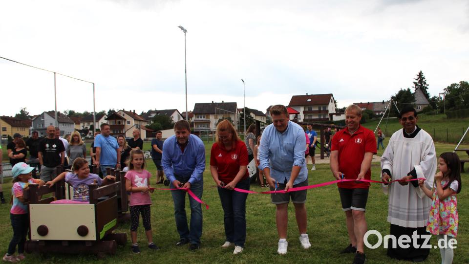 Mit dem Durchschneiden des Bandes wird der Spielplatz „Am Sportplatz“ offiziell eingeweiht. Von links: Zweiter Bürgermeister Ewald Plößner, Nicole Schusser-Schindler (SCK), Marco Streit (MGR), Josef Reisner (SCK) sowie Pfarrer Dr. Augustin Lobo. Bild: lep