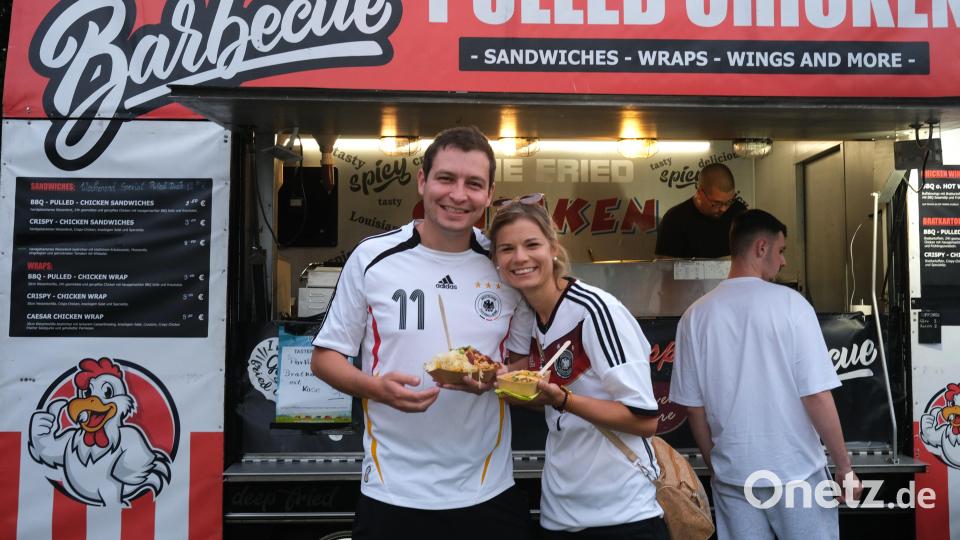 Die Fußballfans Lena Maierl und Klaus Möschl lassen sich durch die Niederlage der deutschen Fußballer den Appetit nicht verderben und genießen das Angebot des Street-Food-Trucks. Bild: Hirsch