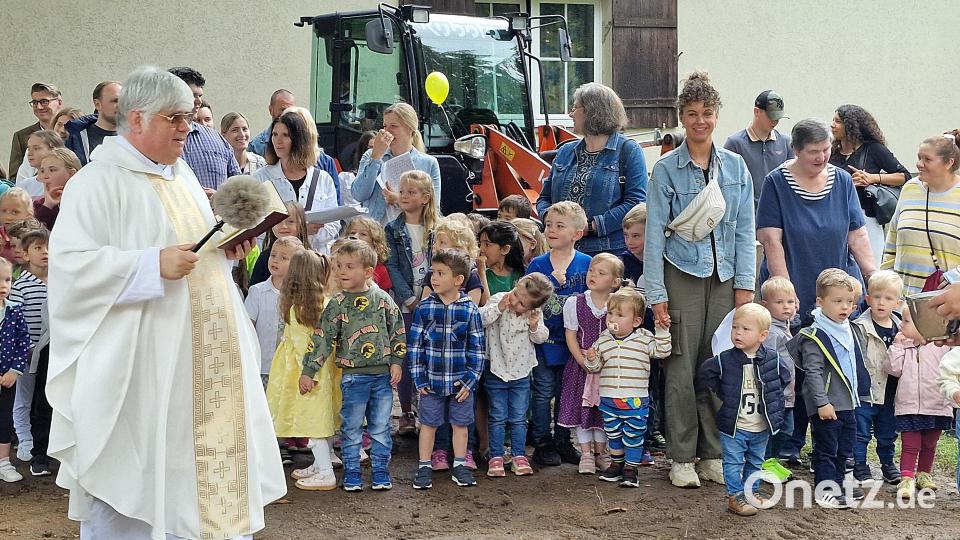 Pfarrer Thomas Jeschner segnet im Beisein der Kinder den neuen Spielplatz. Bild: R. Kreuzer