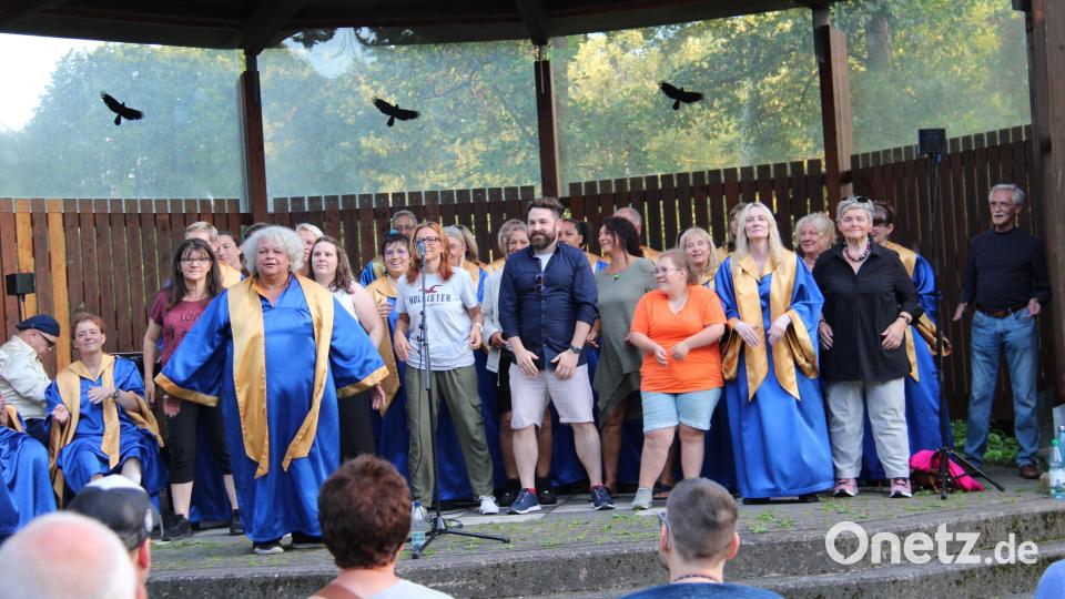 Der Gospelchor "Hope and Joy" unter Leitung von Remona Fink (im Vordergrund) gastiert zum ersten Mal bei der Sommerserenade in der Freizeitanlage. Sie holt Zuhörer zum Mitmachen auf die Bühne. Darunter ist auch Bürgermeister Sebastian Giering (Mitte). Bild: prh