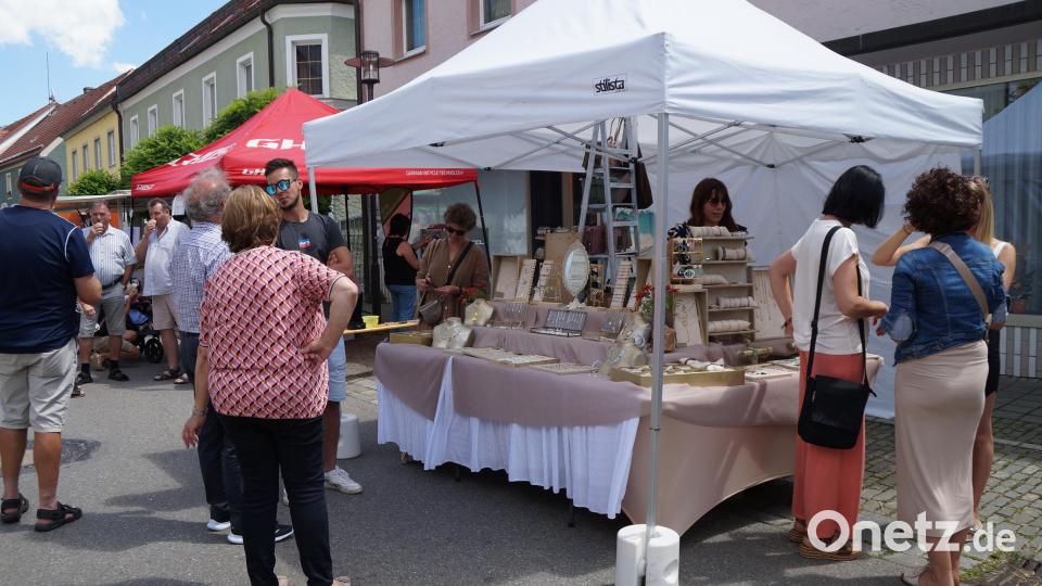 Schmuck, Aufstriche, Säfte, Spielwaren und vieles mehr gibt es an den Ständen. Auch Bürgermeister Reinhard Kreuzer (Dritter von links) ist unter den Gästen und lässt sich ein Eis schmecken. Bild: wel
