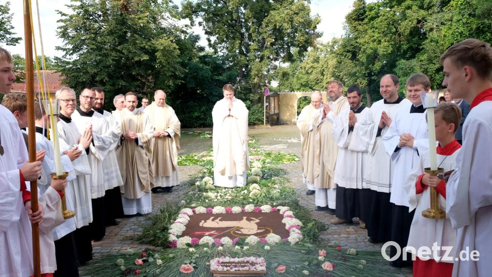 Mit Dankbarkeit und Demut betritt der Neupriester die kunstvoll angefertigten Blumenteppiche auf dem Weg zur Primizmesse. Bild: mab
