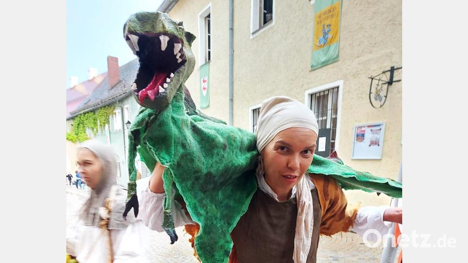 Eine Puppenspielerin (Christiane Joiko) führt auf dem Markt ein schauerliches Drachenspiel vor. Bild: lg