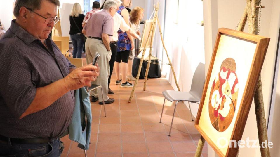 Gäste der Vernissage beim Betrachten der Kunstwerke. Bild: Stadt Tirschenreuth/exb