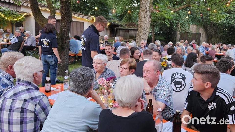 Das begeisterte Publikum unter den schattenspendenden Bäumen des Pfarrgartens genießt die Serenade in Unterauerbach. Bild: ga