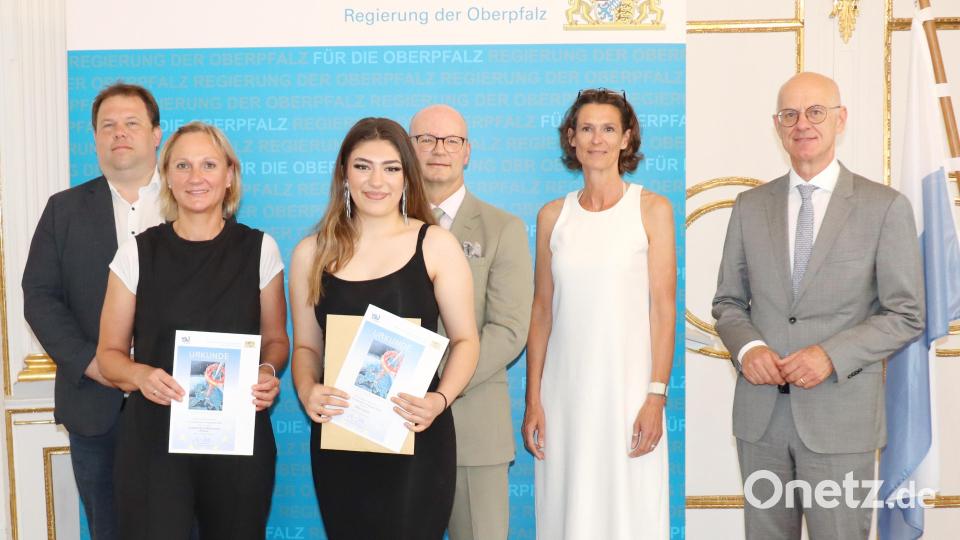 Regierungspräsident Walter Jonas (rechts), Bezirksheimatpfleger Dr. Tobias Appl (links.) und Abteilungsdirektor Thomas Unger (Vierter von links) mit der ausgezeichneten Schülerin Aida Islami und der Schulvertretung der Landgraf-Ulrich-Mittelschule Pfreimd. Bild: Regierung der Oberpfalz/Stühlinger-Weinhändler