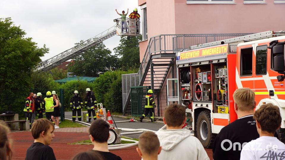 Hinter dem Einsatzfahrzeug der Immenreuther Wehr stand die Kemnather Drehleiter und rettete Heike Haßmann aus dem oberen Stockwerk der Schule. Damit verbunden eine Gratisfahrt nach ganz oben. Bild: bkr