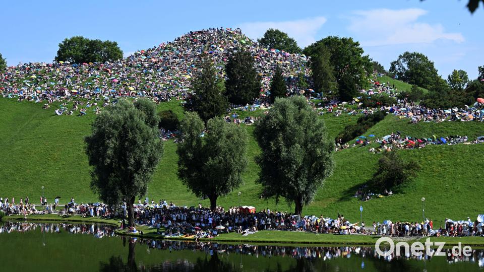 Taylor-Swift-Fans sitzen auf dem Olympiaberg im Olympiapark. Bild: Felix Hörhager /dpa